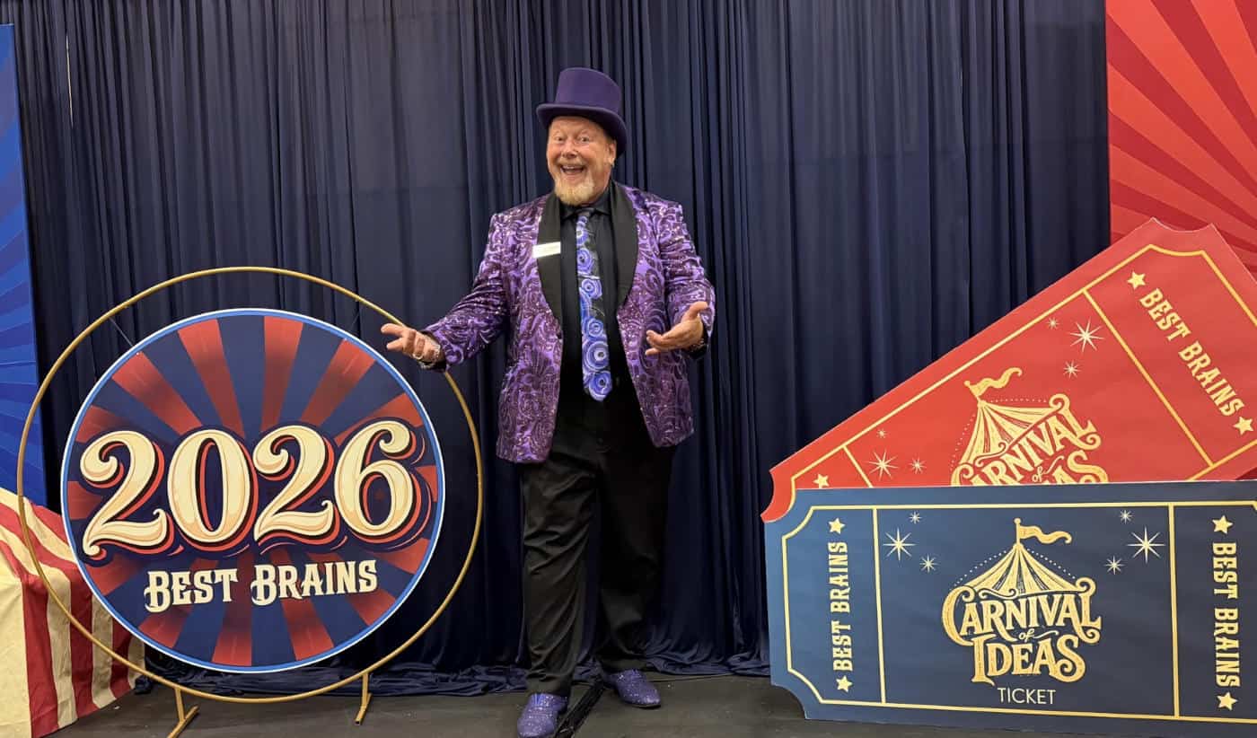 Corporate magician John Measner in a purple sequined jacket and top hat performing at the Best Brains 2026 Carnival of Ideas event